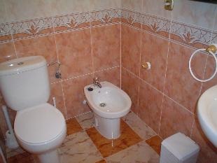 The fully tiled bathroom with bath and overhead showe